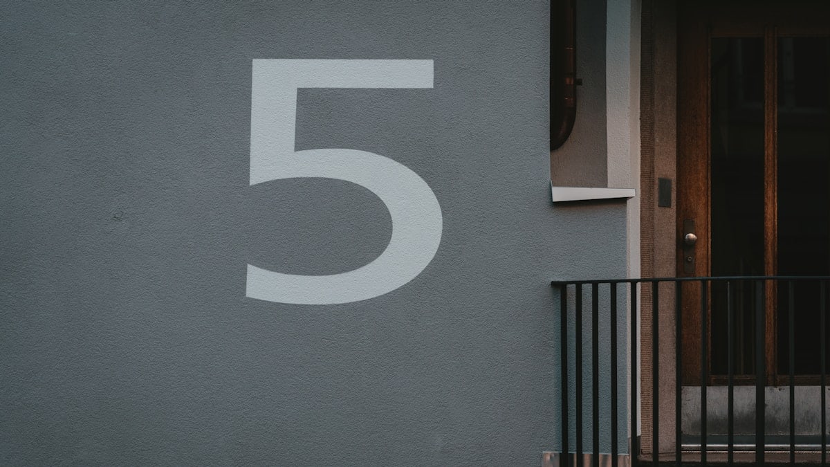 white number 5 print on white concrete wall